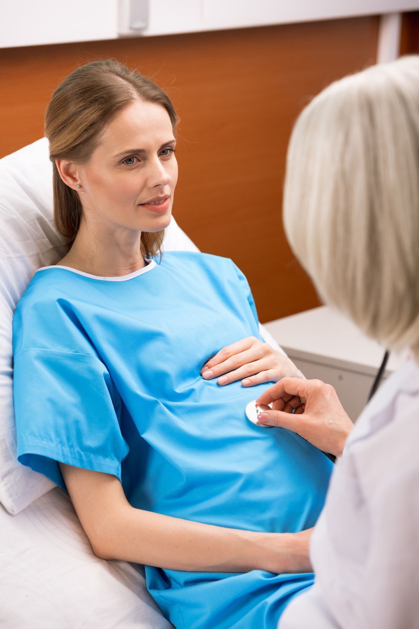 pregnant-woman-lying-on-hospital-bed-and-looking-at-doctor-listening-heartbeat-of-unborn-baby.jpg